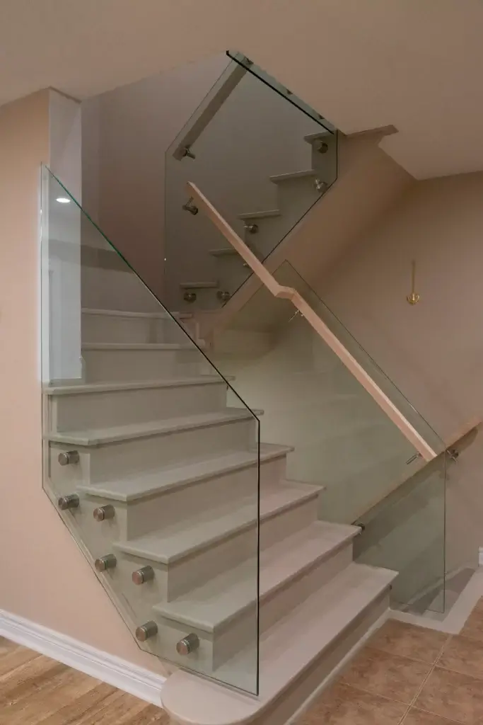 Glass railing installed using a pin system on a two-piece staircase