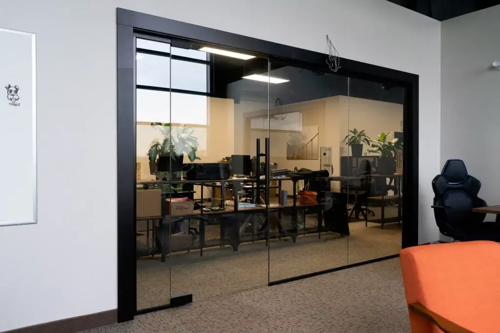 Three-piece glass office partition with wide black frame
